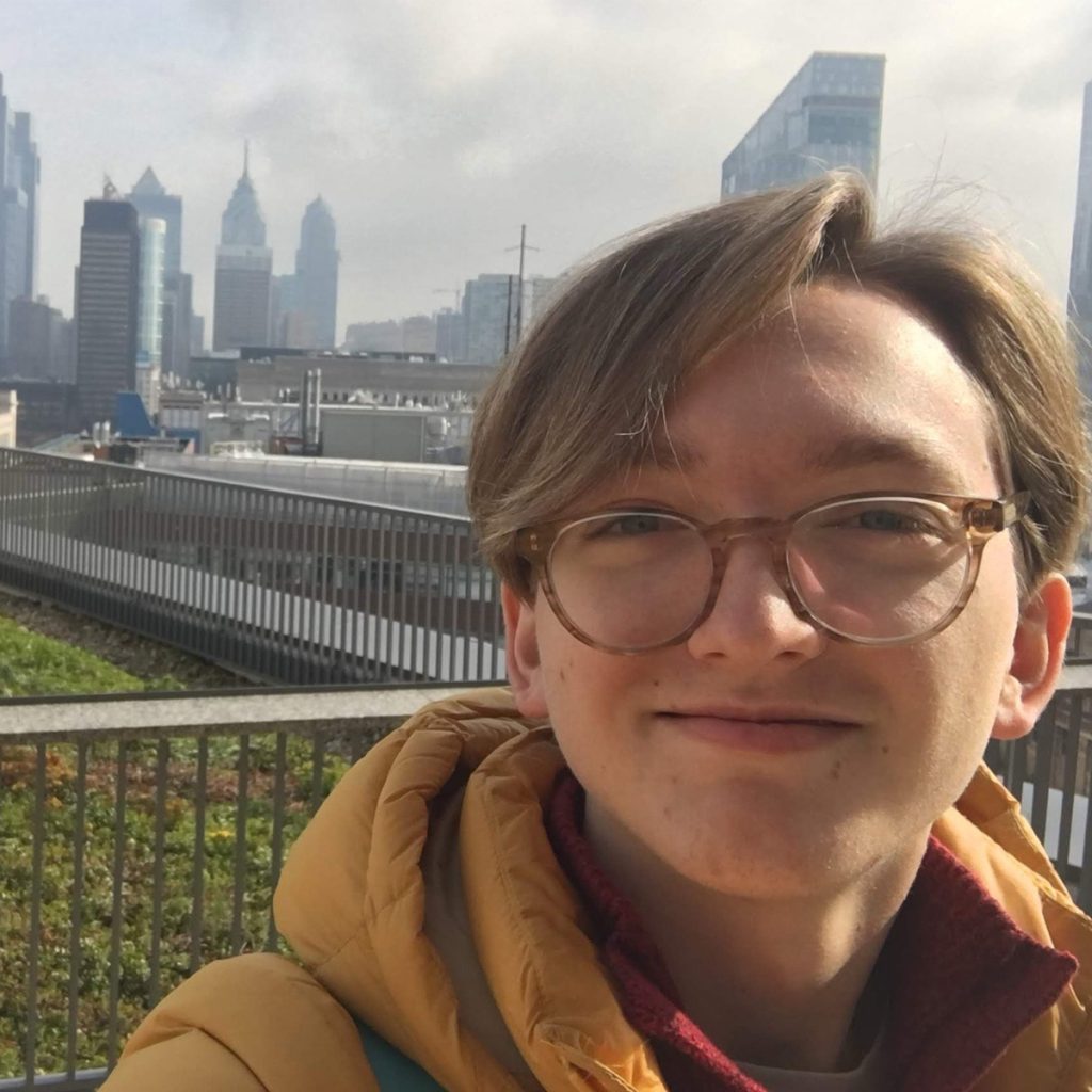 closeup of Zachary K. in front of Philadelphia skyline