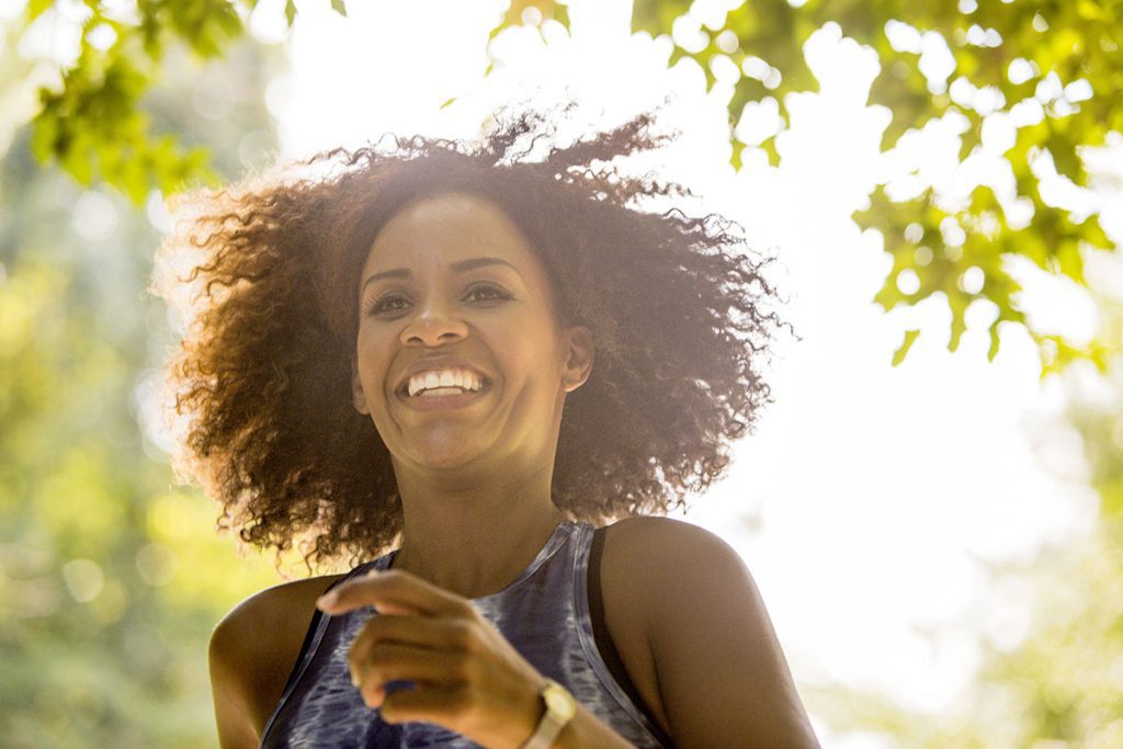 woman smiling outdoors in active attire