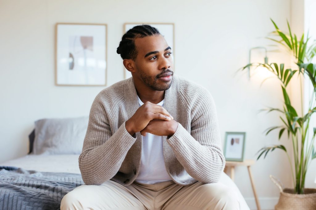 person sitting on bed and deep in thought