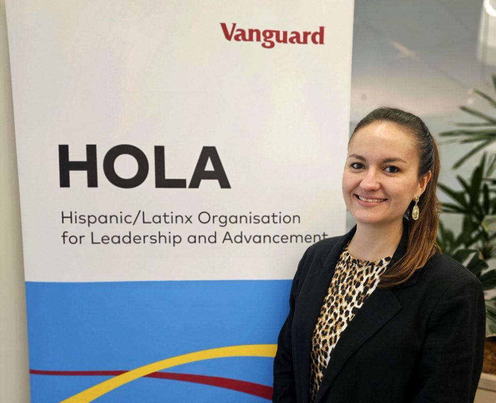 Alejandra R. standing in front of HOLA sign at Vanguard Austrailia office