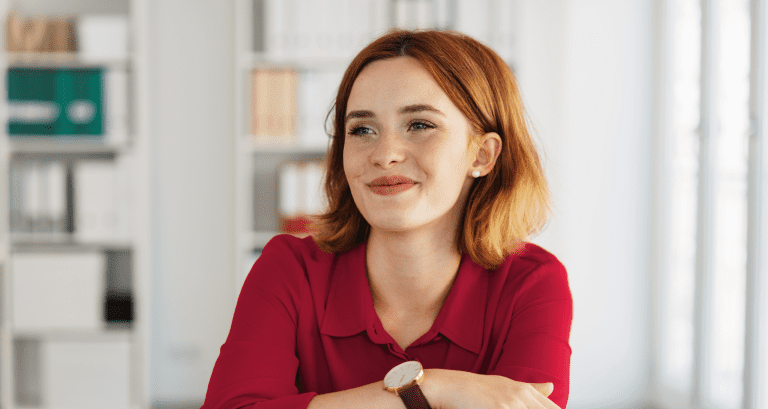 Woman looking away from the camera while smiling, looking content.