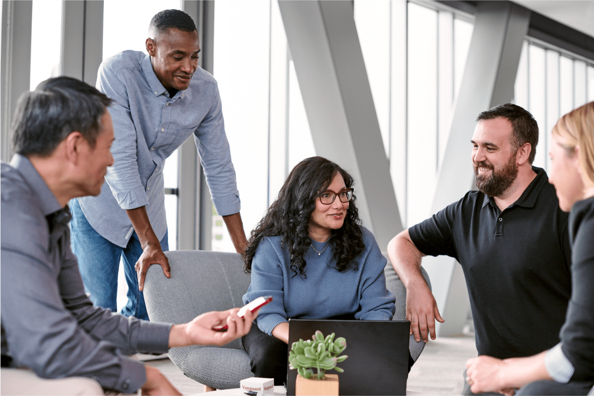 Group of diverse coworkers sitting and talking in a common area at the office.