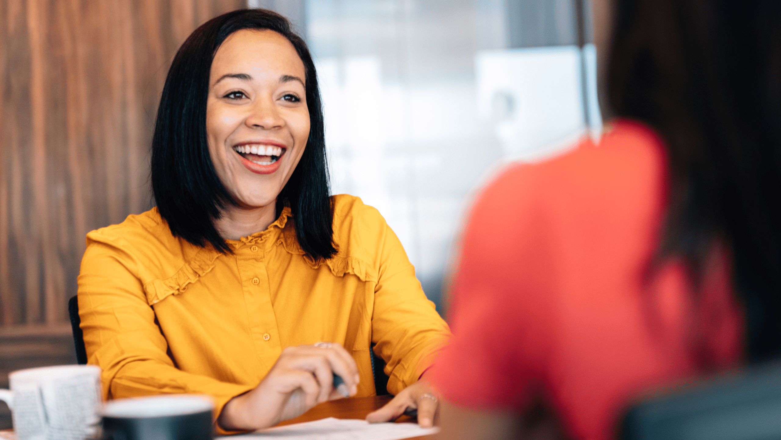 A female student sitting and speaking with her mentor.